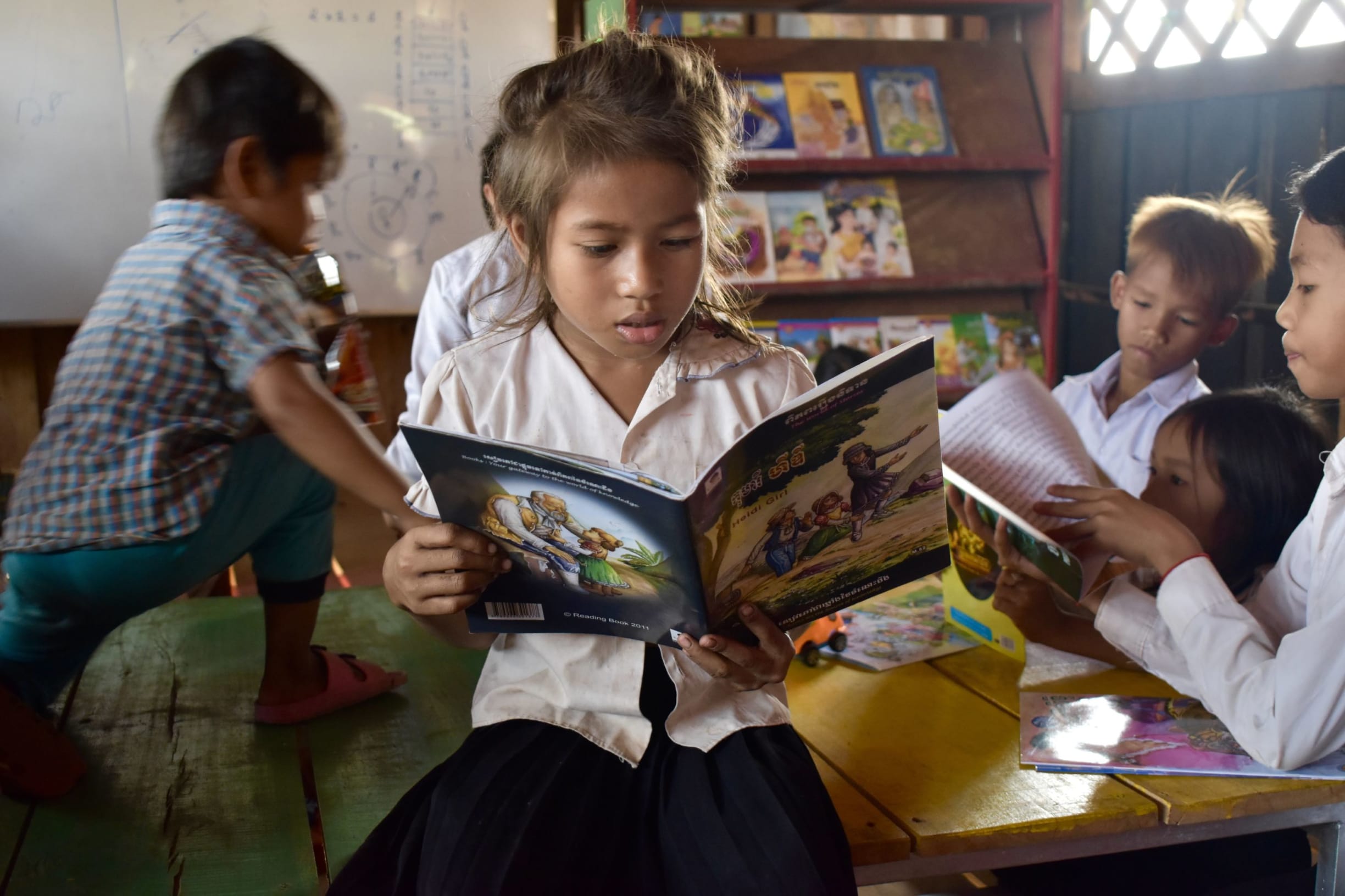Girl reads book in Cambodia. 