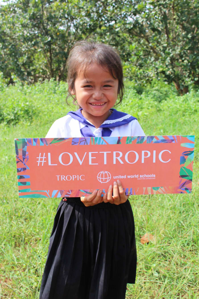 Cambodia student with Love Tropic banner